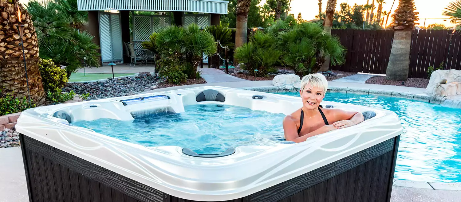 An Artesian Island Spas Elite Grand Cayman Elite hot tub in a backyard setting