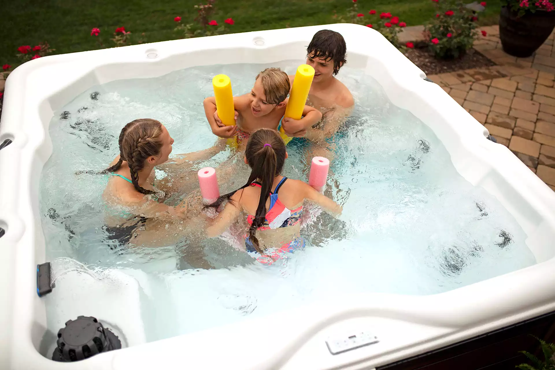Family relaxing together in a warm spa on a cool evening